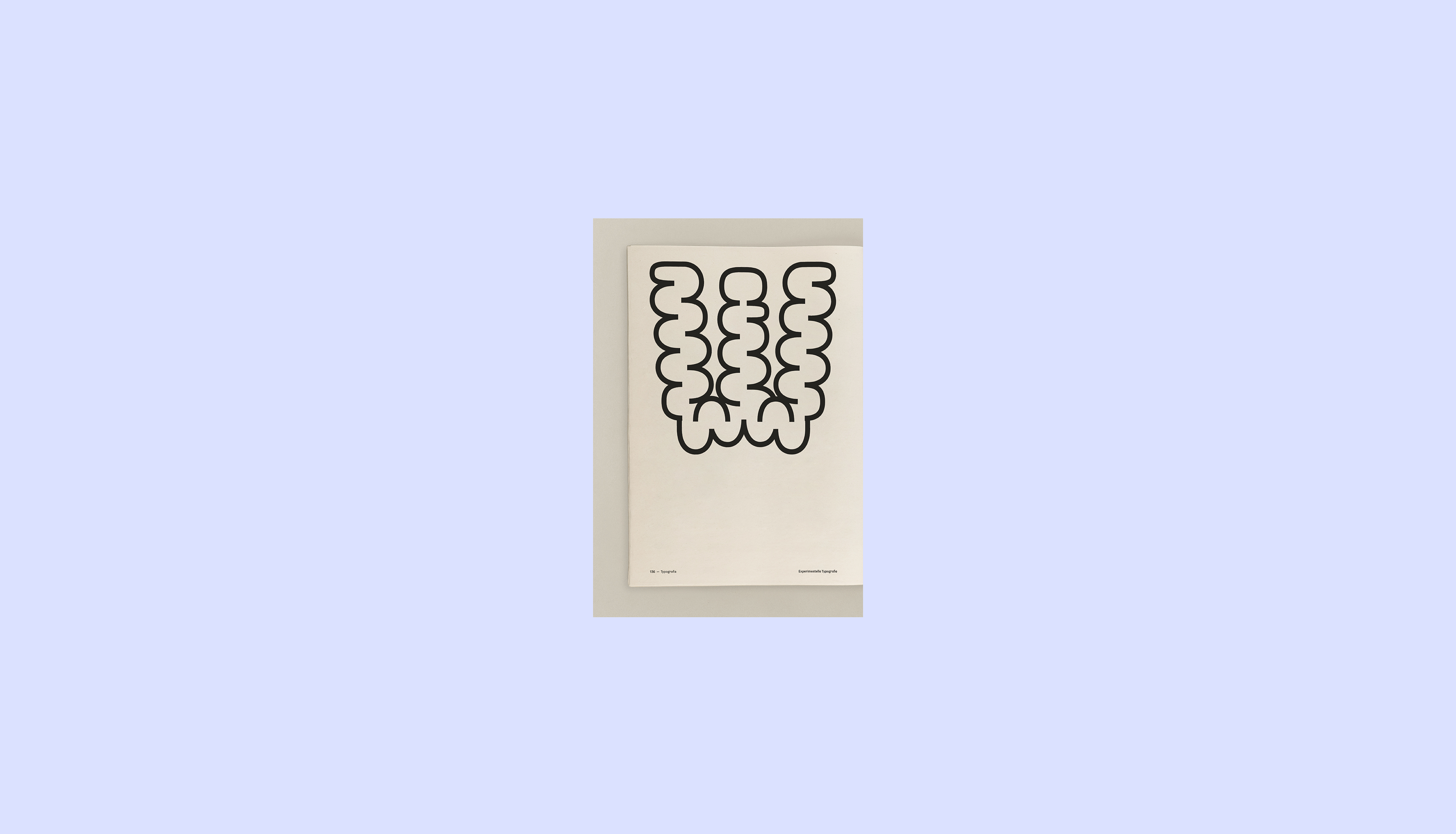 Detailaufnahme einer Seite mit experimenteller Typografie. Ein Buchstabe erstellt mit organischen Formen
